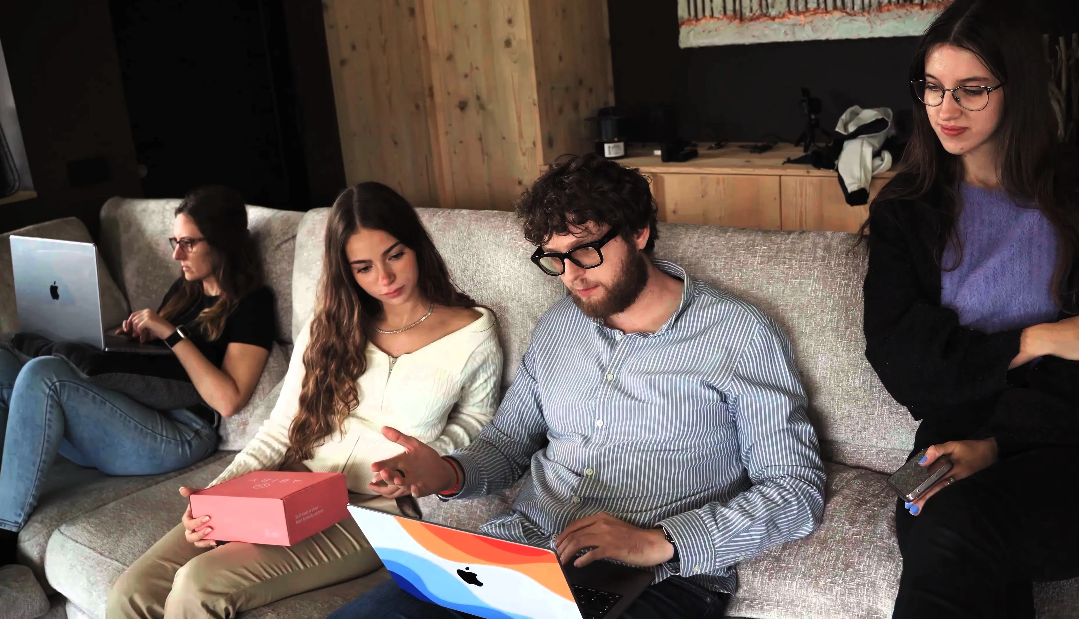 Team 1percent riunito su un divano con un laptop